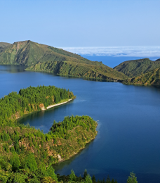 Photo showing scenic volcanic lake surrounded by green mountains
